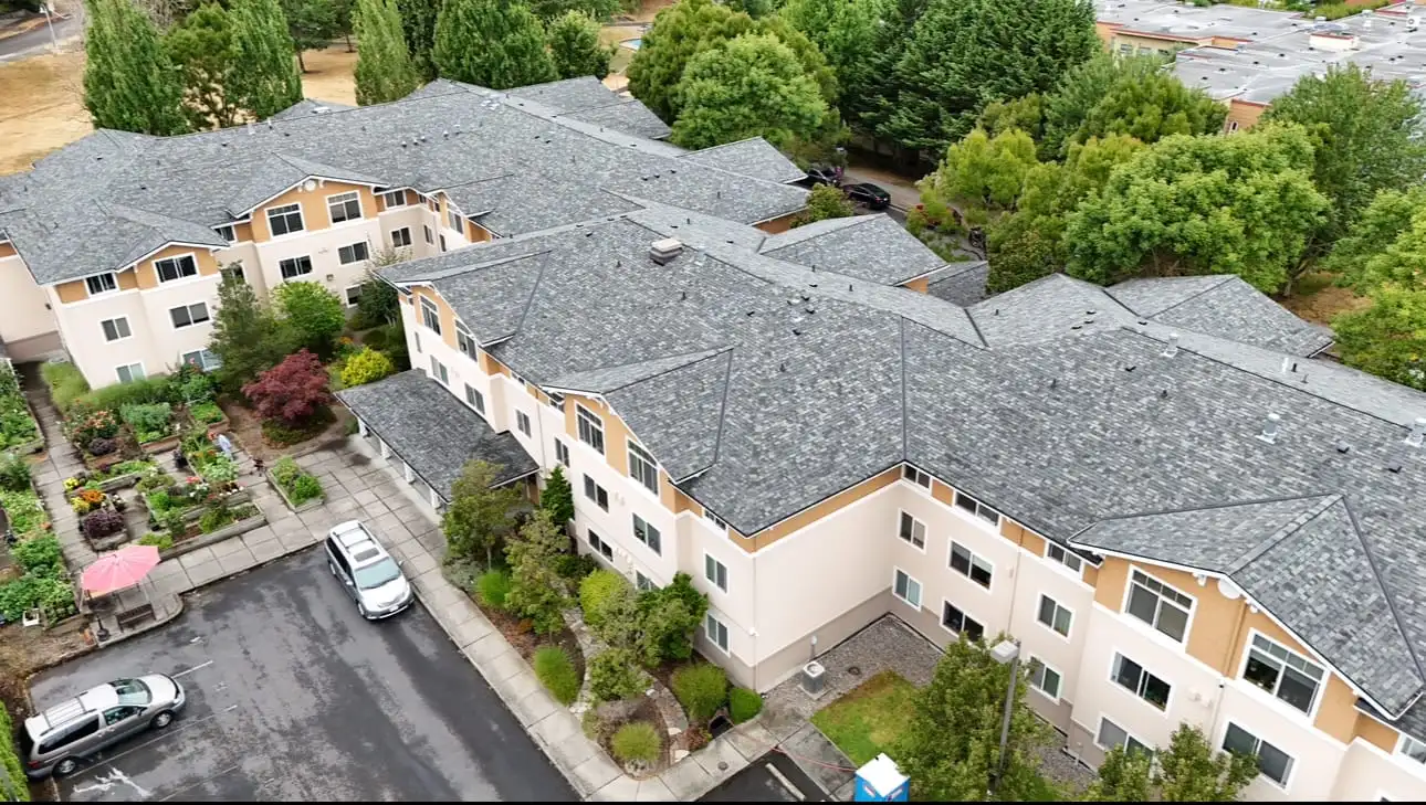Aerial view of an apartment building with completed asphalt shingle roof installation in the Seattle area by K Single Corp